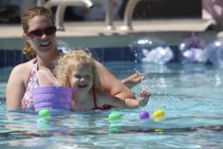 Hannah Sorenson, 3, swims to the floating eggs with the help of her mom, Stephanie, during the underwater egg hunt Saturday hosted by Henderson Parks and Rec at Silver Springs Recreation Center.