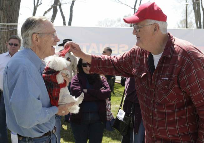 Senate Majority Leader Harry Reid (D-Nev.) holds "Fifi," a toy poodle belonging to Ron Malone, right, during a campaign stop in Lovelock, Nev., Wednesday, April 7, 2010.
