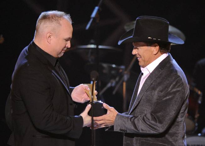 Garth Brooks, left, presents George Strait with the Artist of the Decade Award at the ACM Artist of the Decade All-Star Concert on April 6, 2009, in Las Vegas. 