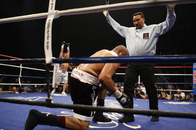 Chris Arreola (left) celebrates as referee Tony Weeks counts out Jameel McCline after he was knocked out in the fourth round of their heavyweight title fight at the Mandalay Bay Events Center in Las Vegas, Nevada, April 11, 2009.