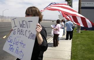 Erin Neff, executive director of ProgressNow Nevada, pickets in front of the main post office on Sunset Road Thursday, April 15, 2010. About a dozen protesters came out to support the services that taxes provide and to demand greater 