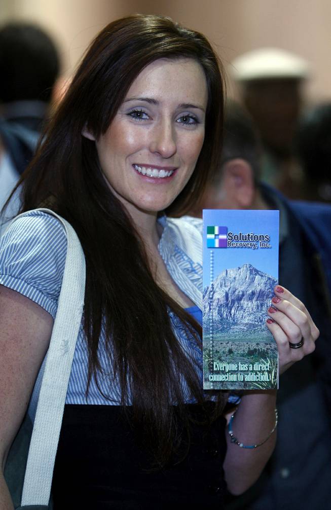 Danuelle Shiflet, an account executive with Solutions Recovery, poses with a company brochure during a seminar designed to help Nevadans take advantage of stimulus funding at the Mandalay Bay Thursday. 