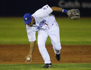 Las Vegas shortstop Angel Sanchez fields the ball bare-handed during the 51s home opener Friday against Colorado Springs. Las Vegas won 3-2. 