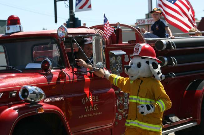 Captain Sparky walks along a fire truck in the Heritage Parade.