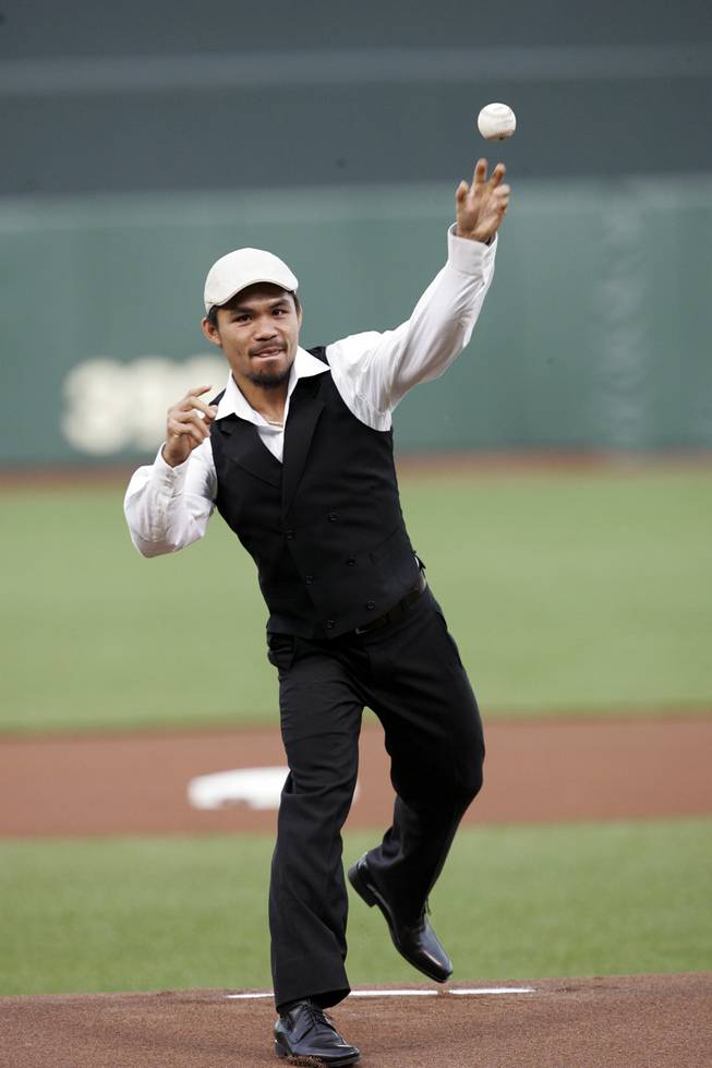 Boxer Manny Pacquiao, of the Philippines, throws the ceremonial first pitch before a baseball game between the San Francisco Giants and San Diego Padres in San Francisco, Tuesday, April 21, 2009.