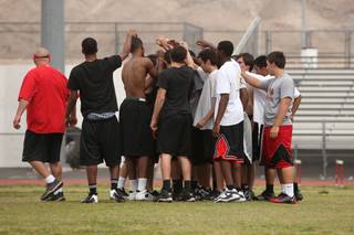 Members of the Las Vegas High football team gather at the end of practice last week. The Wildcats are one month into their spring football program, working on everything from conditioning to learning a new defense. More than 50 varsity players attend practices, which are involuntary and three times each week until the summer.