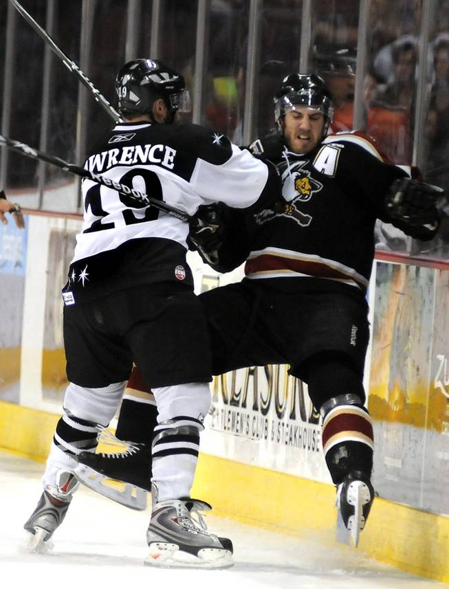 Wranglers left winger Mick Lawrence sends Bakersfield Condors forward Andrew Ianiero into the boards on Apr. 21.