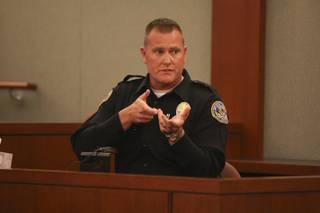 Henderson Police Officer John Bozarth demonstrates Friday how he held his AR-15 rifle while entering the emergency room at St. Rose Dominican Hospitals-Siena Campus while testifying during the coroner's inquest into the fatal shooting of Charles Bradley Campbell.