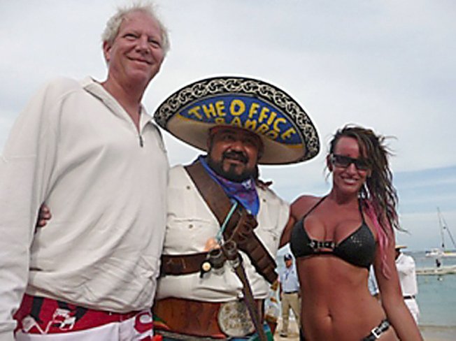 Jim and Glynda Rhodes pose with a bartender this month on a beach in Cabo San Lucas, Mexico. His company had filed for bankruptcy protection on March 31.