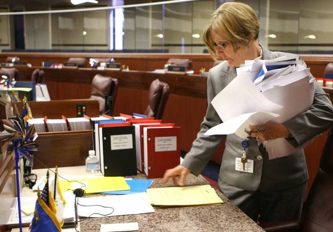 Nevada Assembly Sergeant at Arms Mary Mathews collects paperwork from desks in the lower chamber on Tuesday, which was the deadline day for moving bills to the Senate. Between both houses of the Legislature, more than 950 bills were introduced. It remains to be seen how many pass. 