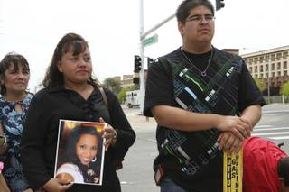 Peggy Tejido holds a photograph of her daughter while standing with her mother, Rosalinda Garcia, left, and Chris Torres, 21, the fiance of Verlaine May Powless, during the dedication ceremony of a newly installed stoplight at the intersection of Wigwam Avenue and Las Vegas Boulevard. Tejido's 19-year-old daughter, Verlaine May Powless, was struck and killed by a vehicle in the intersection July 25, 2008.