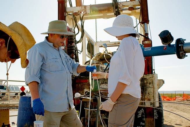 Duane Moser, left, a microbial and molecular ecologist at the Desert Research Institute, and technician Patty Edmiston take underground water samples in the Amargosa Valley in 2010. The sampling was done in collaboration with Nye County Nuclear Waste Repository Project. Moser is part of a team of researchers that just received a $6.6 million NASA grant to explore life underground.
