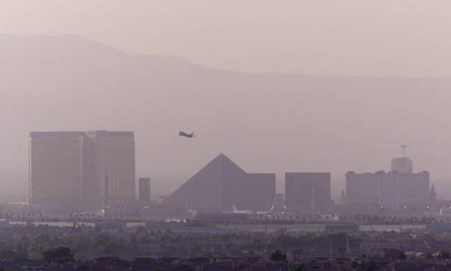 An airplane takes off from McCarran International Airport as hotel-casinos on the Strip are partially shrouded in haze in this Sun file photo from 2001.  