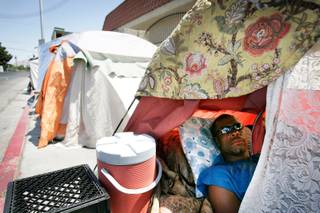 A man who wished not be identified sits inside his tent in the homeless encampment on Foremaster Lane between Las Vegas Boulevard North and Main Street in Las Vegas on Friday, May 15, 2009. 