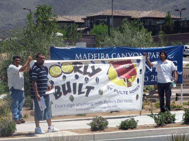 From left, Lazara Acune, Edgar Garcia and Signacao Soto picket Pulte Homes outside Madeira Canyon Park during its grand opening celebration Saturday.