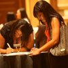 Keona Everage, right, and Sonya James fill out applications Tuesday during the Opportunity Boulevard Summer Career Fair at Green Valley Ranch in Henderson.