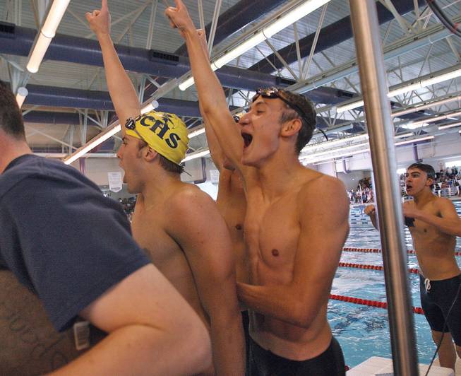 Boulder City swimmers Michael Satterlee, left,  John Lyon, right, and Cameron Walker, celebrate after defeating Green Valley in the men's 200-yard freestyle relay during the 4A Sunset Region swim meet at the Desert Breeze Aquatics Center.