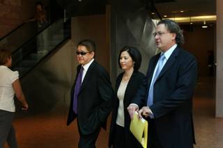 Terrance K. Watanabe, 52, left, of Omaha, Neb., leaves the Regional Justice Center following his arraignment in Las Vegas on Wednesday, accompanied by sister Pam Watanabe-Gerdes and attorney David Chesnoff. 