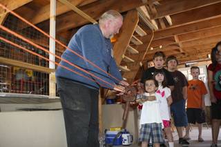 Chahime Kraba, 4, tugs hard while making a rope with the assistance of ropemaker John Nelson in the horse barn Saturday during Centennial Day at the Clark County Museum.