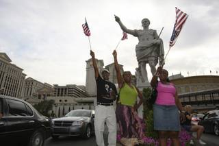 Waving American flags above their heads, supporters of President Obama and U.S. Sen. Harry Reid, D-Nev., from left, Kennith Dean, Paris Lane and Tammy Vincent, scream 