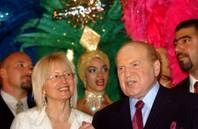Owner and operator of the Venetian on the Las Vegas Strip, Sheldon Adelson, next to his wife Miriam, left, in front of Las Vegas show girls during the opening of the Las Vegas Sands casino in Macau Tuesday, May 18, 2004.