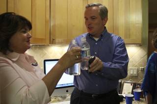 Candidate Cam Walker toasts his water bottle with campaign official Sylvia Harber, left, after the first precinct results showed Walker leading in the race for a seat on the Boulder City Council during his watch party Tuesday at Kirk and Vivian Harrison's home.