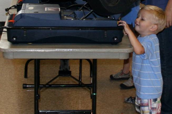 Brennan Noorda plays with a voting machine at Valley View Recreation Center in Henderson while his mom, Catherine, votes.