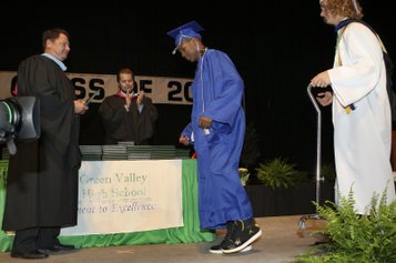 LaQuan Phillips walks across the stage on his own to receive his diploma from Southeast Region Assistant Superintendent Pat Skorkowsky, left, during the Green Valley High 2009 graduation ceremony Tuesday at the Thomas & Mack Center.