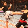 In this photo released by The Rose Group Gina Carano, left, kicks Julie Kedzie during the Elite Xtre