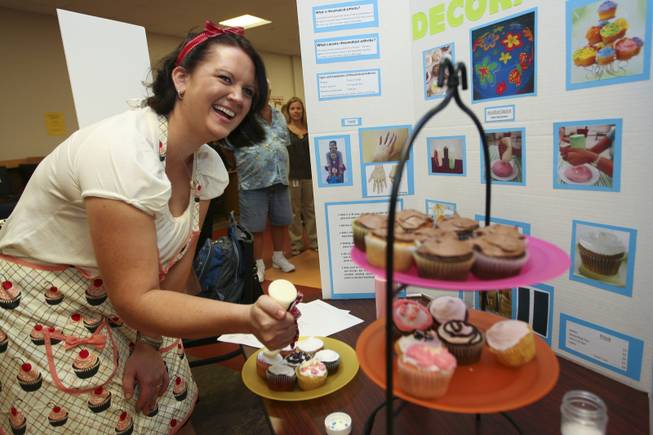 Ingrid Kelly laughs with other students while demonstrating her cake decorating squeeze bottles with grips invention Thursday during the annual student Assistive Technology Fair at Touro University.