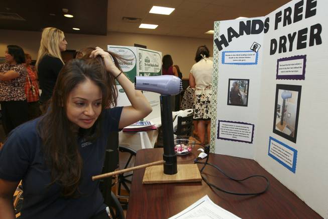 Mayra Olivares demonstrates how her hands-free dryer invention helps stroke victims Thursday during the annual student Assistive Technology Fair at Touro University.