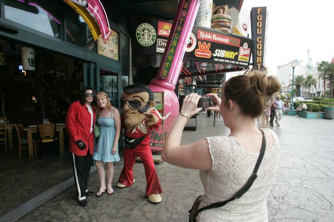 A tourist who only gave her name as Stacy poses for a photo with Michael Jackson impersonator Chris Gardner and foam Elvis Tony Montana outside La Salsa Cantina on the Strip.  