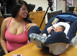 Crystal Quintana looks over at her newborn son, Julian, during a videoconference Monday at St. Rose Dominican Hospital - Rose de Lima Campus. The call was set up by Freedom Calls Foundation, which helps connect servicemen and women in Iraq with their families back home free of charge.