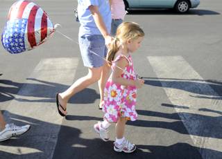 Jordan Ramirez, 4, walks with her mother, Lunde, toward the route of the Summerlin Council Patriotic Parade on Saturday, July 4.