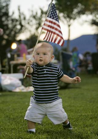 Sebastian Zavila marches around Veterans Memorial Park in Boulder City with an American flag before the start of fireworks Saturday, July 4, 2009. 