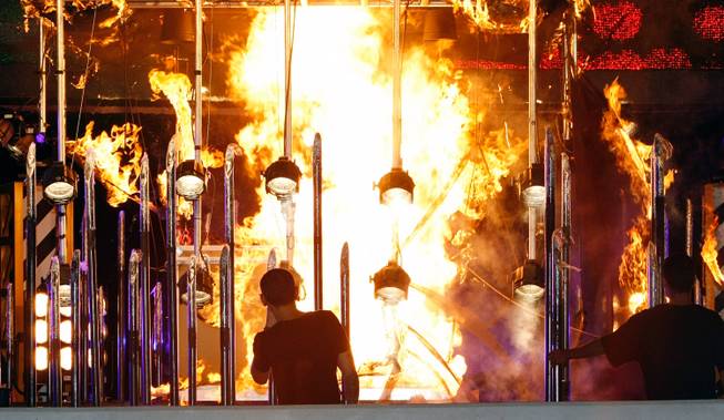 On Saturday at the Miracle Mile Shops at Planet Hollywood, magician Steve Wyrick attempted a stunt called the "Death Drop." After Wyrick was locked in a box, the ropes attached to the box that attached it to a crane were lit on fire. The fire flared up but was extinguished before the box was raised up in the air. Wyrick reappeared in a helicopter that landed on Las Vegas Boulevard between Planet Hollywood and CityCenter. Here, Linkin Park frontman and Club Tattoo co-owner Chester Bennington watches with the stunt.