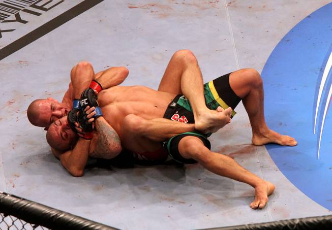 Georges St. Pierre, top, controls Thiago Alves during their UFC 100 match at Mandalay Bay. The welterweight champ retained his title with a unanimous decision victory.