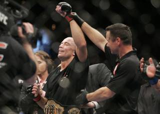 Georges St. Pierre has his arm raised after defeating Thiago Alves in their welterweight title fight at UFC 100. St. Pierre won by decision to retain his title.