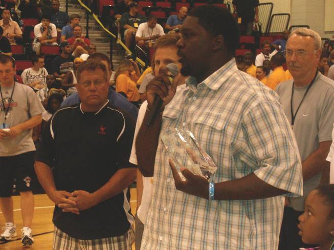 Anthony Manor speaks to the crowd before a summer league basketball game Sunday after accepting an award on behalf of his younger brother, James. James Manor's former Clark High School basketball coach, Brad Query (left), called him a natural born leader and very intelligent person.