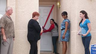Rosa Santana gives a smile as she opens the door to her new home. Three homes were dedicated Friday by Habitat for Humanity and its sponsors to families.