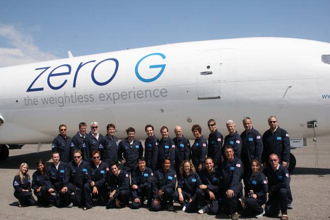The group poses for a photo in front of the ZERO-G plane. 