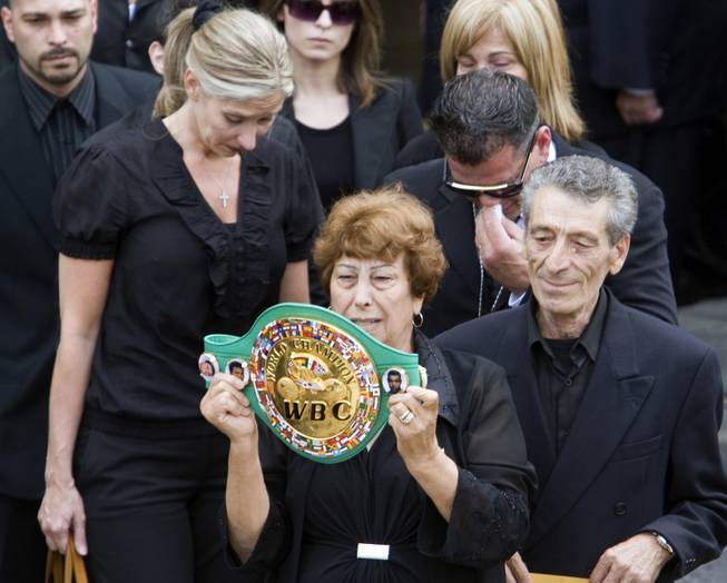 Arturo Gatti's mother Ida, holds his Championship belt as she leaves the church with his step-father, Geraldo Di Francesco and family members after funeral services for the former world champion boxer in Montreal Monday, July 20, 2009.