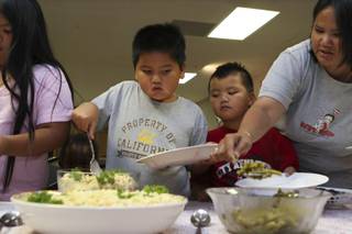 Kristine Tranate helps her sons, Cyrus, 6, and Ethan, 7, fill their dinner plates at Grace Community Church.  The Tranate family is one of four homeless families who stayed at Grace Community Church via the nonprofit organization Family Promise.
