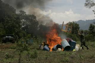 Mexican army soldiers burn laboratory equipment used to produce large quantities of synthetic drugs at a clandestine drug laboratory allegedly run by Mexico's powerful La Familia drug cartel, near the town of Charo, in the state of Michoacan, Mexico, Sunday, July 26, 2009. According to federal law enforcement authorities, the lab produced about 220 pounds (100 kilograms) of methamphetamine or crystal meth,  each week. So far this year, police say they have seized 40 drug labs operated by the La Familia cartel. 