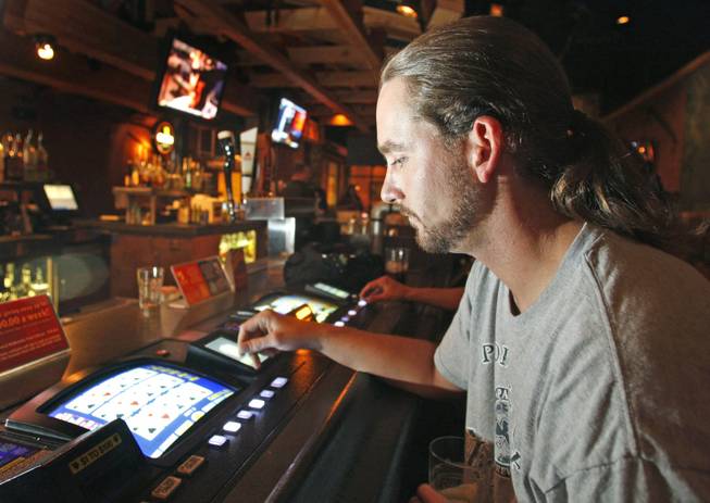 Slot allure: A video poker player is shown at Timbers Bar & Grill on Maryland Parkway. 
