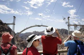 Tourists take in the view of the Hoover Dam bypass bridge from the Hoover Dam observation deck.