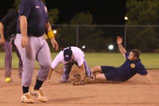 Fire department explorer Jordan Vivone slides in safe at second base under Officer Dave Carpenter Tuesday during the annual National Night Out Boulder City Police-Firefighters' softball game at Veterans Memorial Park.  The police beat the firefighters 14-13.