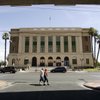 Pedestrians pass by the old courthouse and U.S. post office, the site of the Mob Museum, in downtown