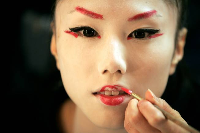 Ayuri Iisaku puts on her makeup before a performance of ...