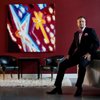 In a new suit, artist Jerry Misko poses in front a painting for his new show, 